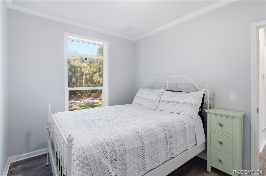 A PEACEFUL PLACE TO UNWIND! This inviting BEDROOM features soft neutral colors, attractive flooring, crown molding & a large window overlooking the beautiful natural surroundings.