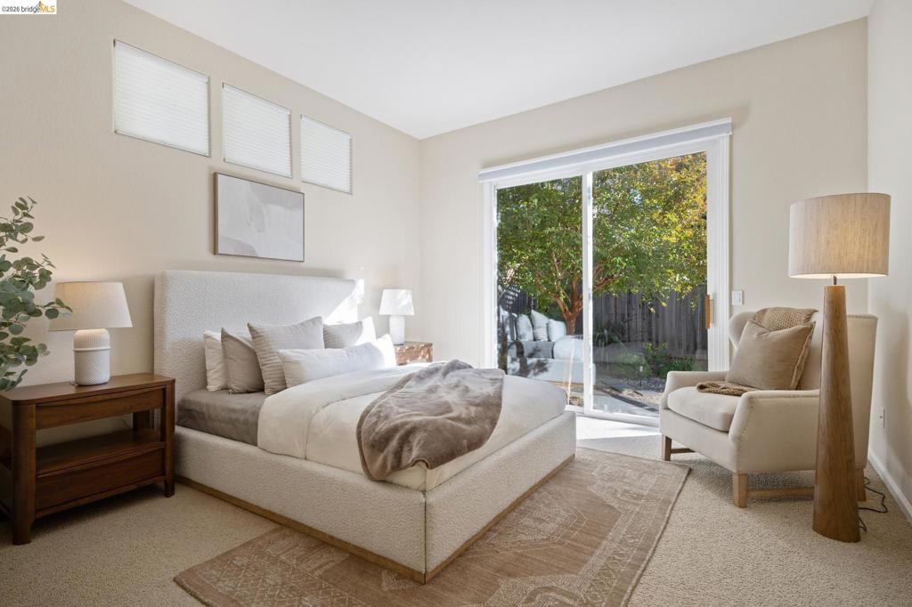 Neutral interior featuring carpeted flooring, three high-placed rectangular windows, and large sliding glass doors