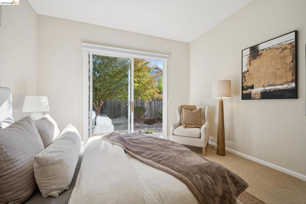 Sliding glass door with white frame and neutral carpeting