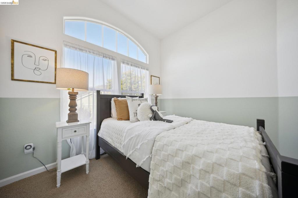 Arched window, dual-tone wall paint, and neutral carpeting