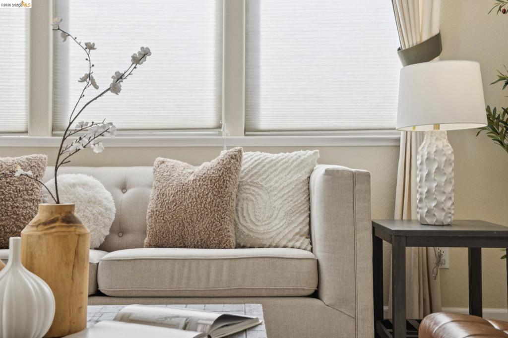 Multi-pane window configuration featuring cellular shades and floor-length drapery
