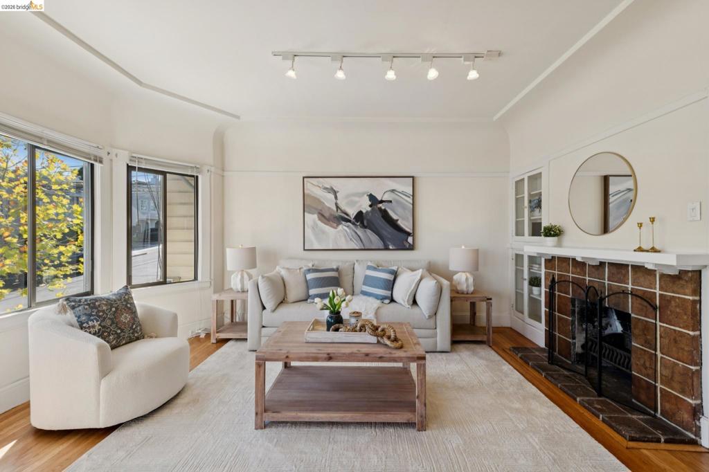 a tile-surround fireplace with a mantel, built-in glass-front cabinetry, curved architectural detailing