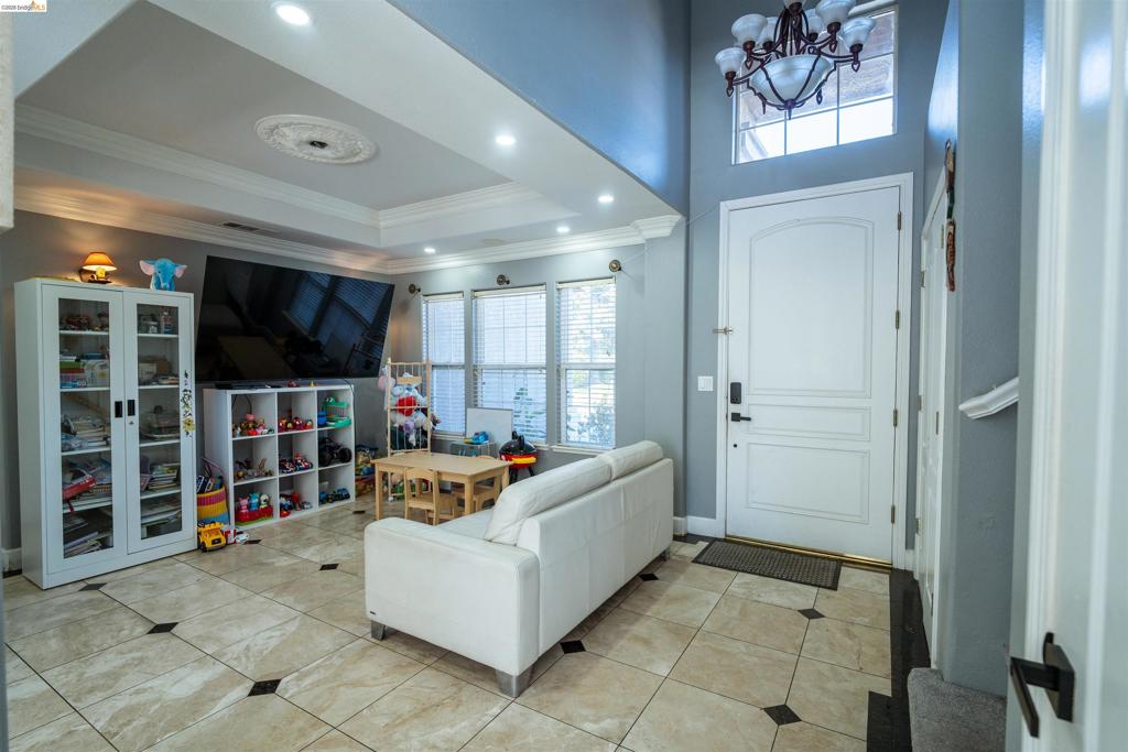 Entry featuring vaulted ceilings, recessed lighting, tile flooring with decorative stone insets, a multi-pane arched transom window, and a ceiling medallion