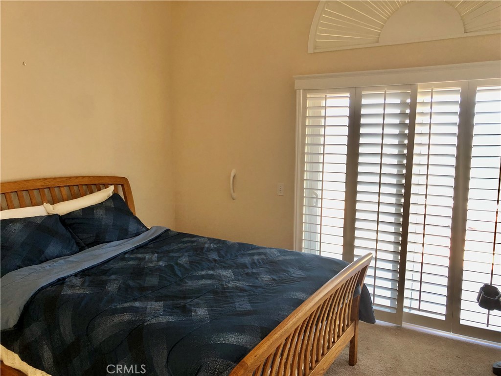 Primary bedroom with sliding glass doors that open to back yard patio - letting in that ocean breeze!
