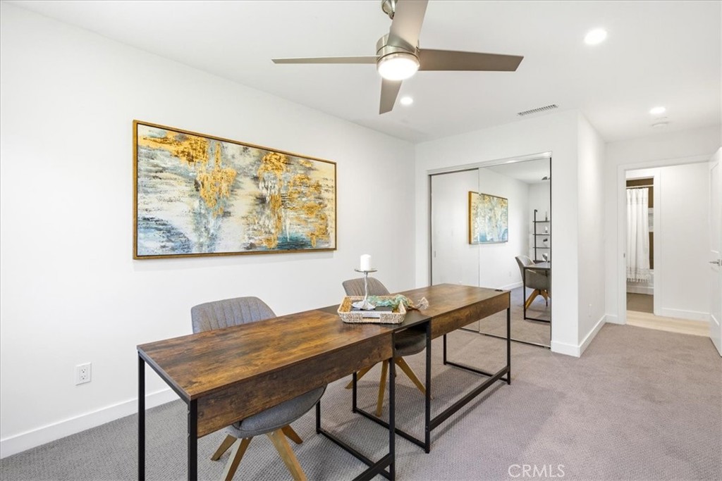 Office or flex space with a work table and ceiling fan.