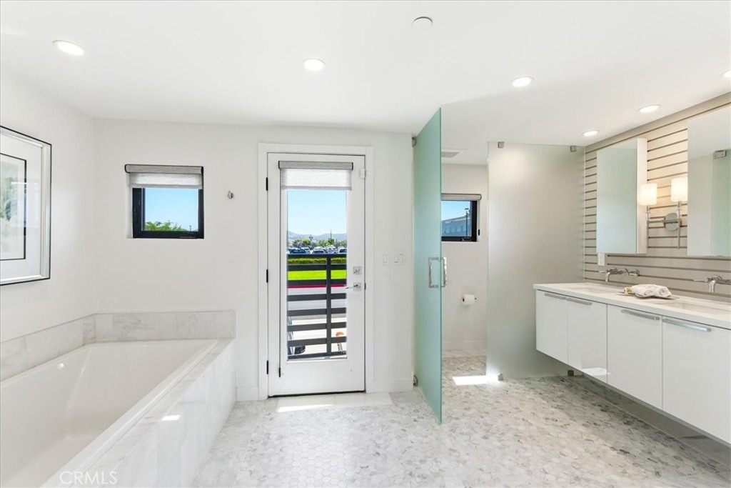 Primary bath with a soaking tub and balcony access.