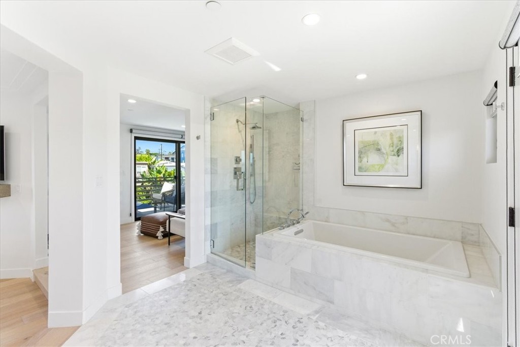 Bathroom with a soaking tub, walk-in shower, and balcony access.