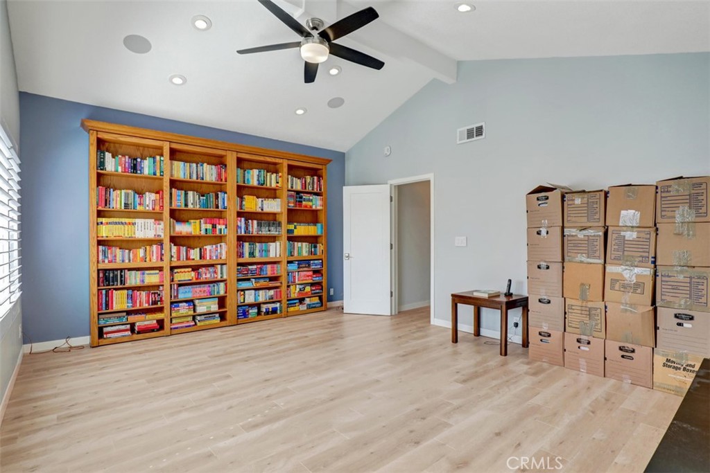 Family room bookcase opens and there is a closet the full length of the bookcase behind.
