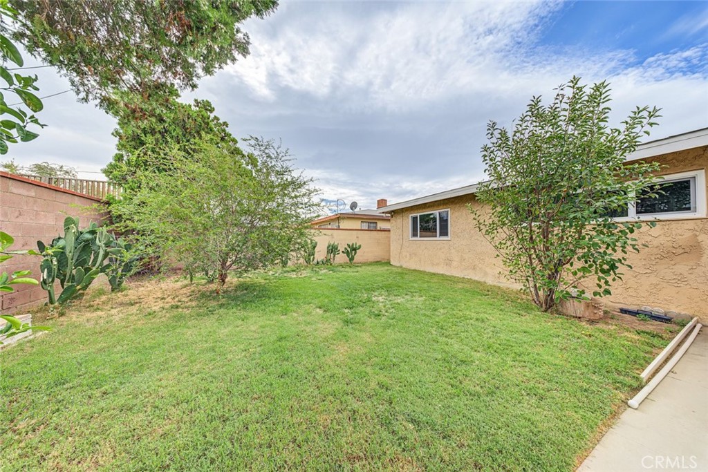 Backyard is landscaped and has mature trees, block walls as well.