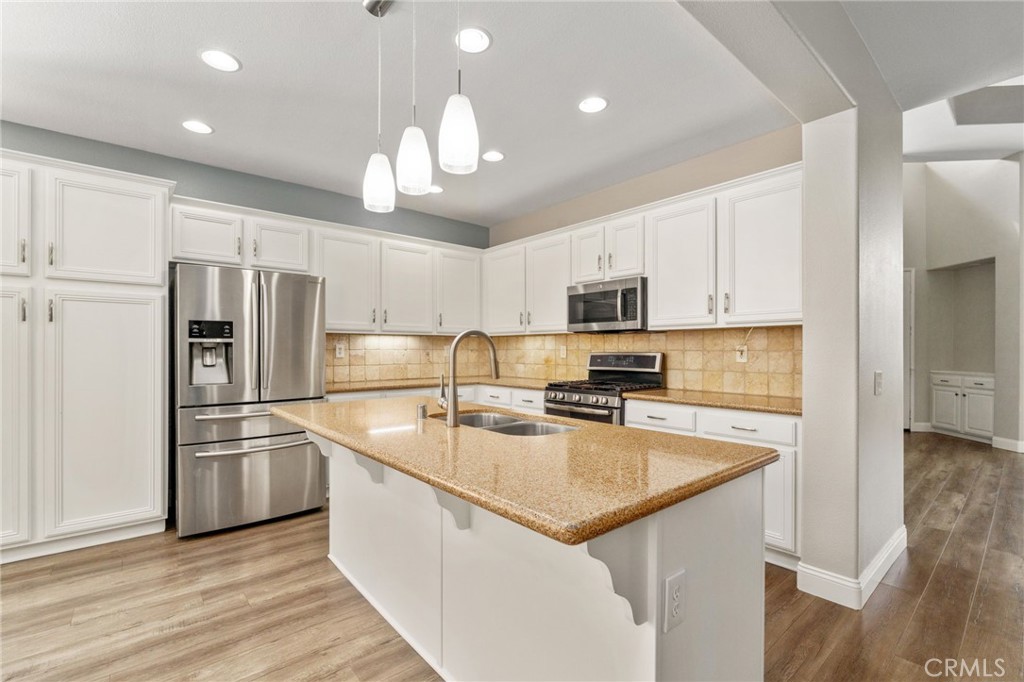 Another View Of The Beautiful Kitchen Showcasing The Generous Center Island With Breakfast Bar, Stainless Steel Appliances, Attractive Countertops, And Abundant Cabinet Space.