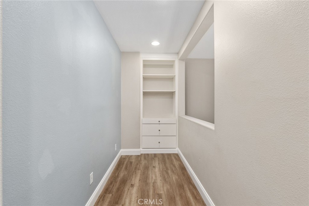 Versatile Upstairs Nook Featuring Built-In Shelving And Cabinetry, Wood-Look Flooring, And A Convenient Space For A Home Office Or Study Area.