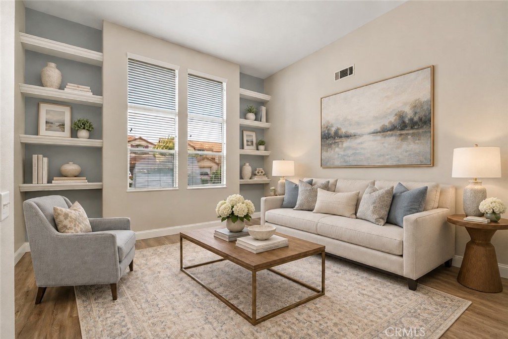 Spacious And Versatile Front Room Featuring Built-In Shelving, Large Windows, And Wood-Look Flooring, Offering An Inviting Space For A Sitting Room Or Additional Living Area. Digitally Staged
