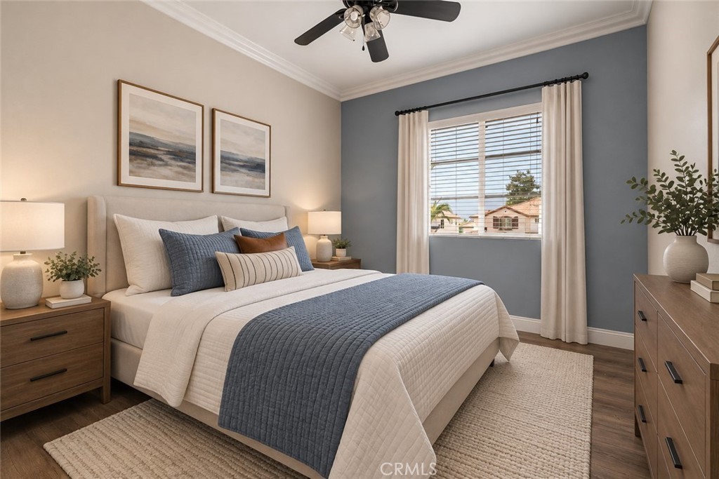 Spacious Secondary Bedroom Featuring An Attractive Accent Wall, Crown Molding, Ceiling Fan, Wood-Look Flooring, And A Large Window Providing Natural Light. Digitally Staged