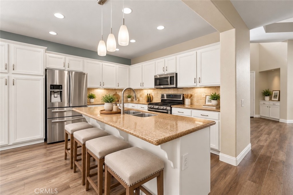 Another View Of The Beautiful Kitchen Showcasing The Generous Center Island With Breakfast Bar Seating, Stainless Steel Appliances, Attractive Countertops, And Abundant Cabinet Space. Digitally Staged