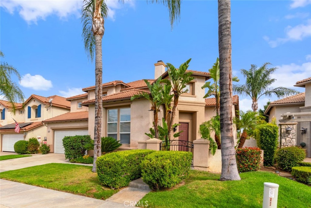 Attractive Exterior Showcasing The Home's Architectural Details, Lush Green Lawn, Mature Palm Trees, And Manicured Landscaping.