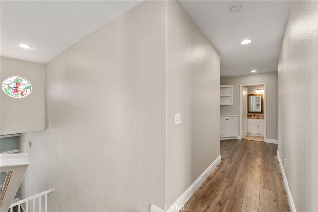 Spacious Upstairs Hallway Featuring Wood-Look Flooring, Recessed Lighting, And An Open View Overlooking The Staircase.