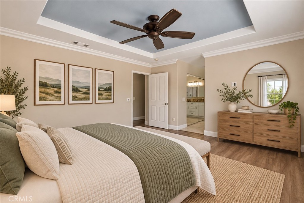 Another View Of The Spacious Primary Suite Highlighting The Elegant Tray Ceiling, Generous Floor Space, And Convenient Access To The Private Primary Bathroom. Digitally Staged