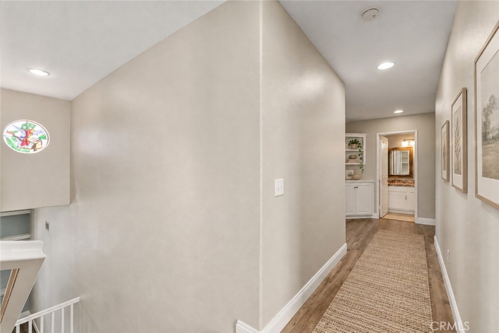 Spacious Upstairs Hallway Featuring Wood-Look Flooring, Recessed Lighting, And An Open View Overlooking The Staircase. Digitally Staged