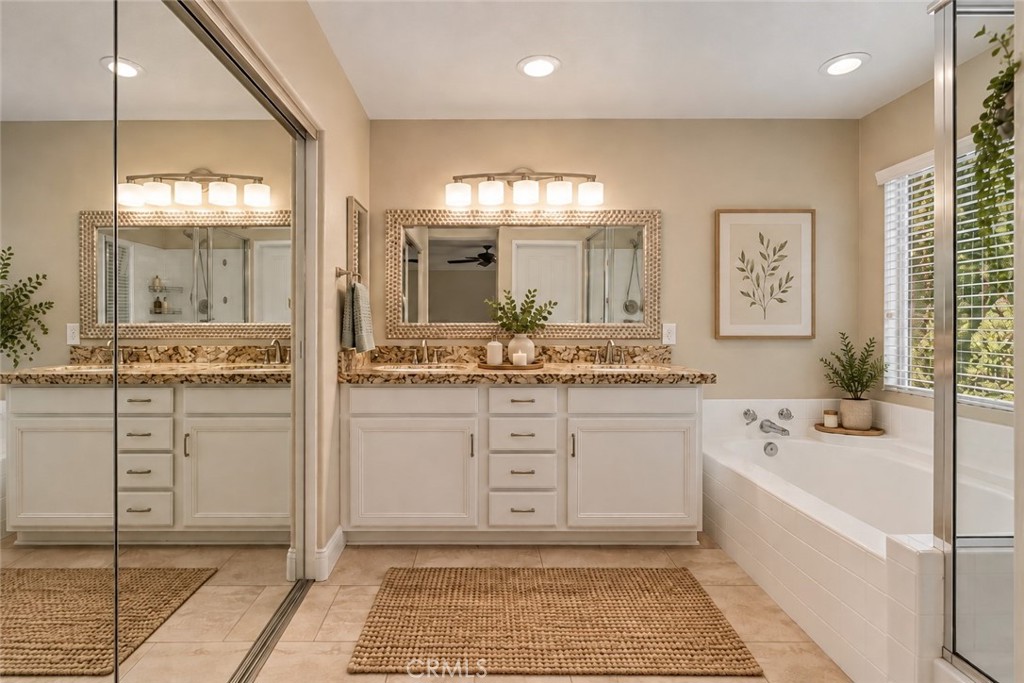 Spacious Primary Bathroom Featuring An Expansive Vanity With Generous Counter Space, Framed Mirror, Relaxing Soaking Tub, And Separate Glass-Enclosed Shower. Digitally Staged