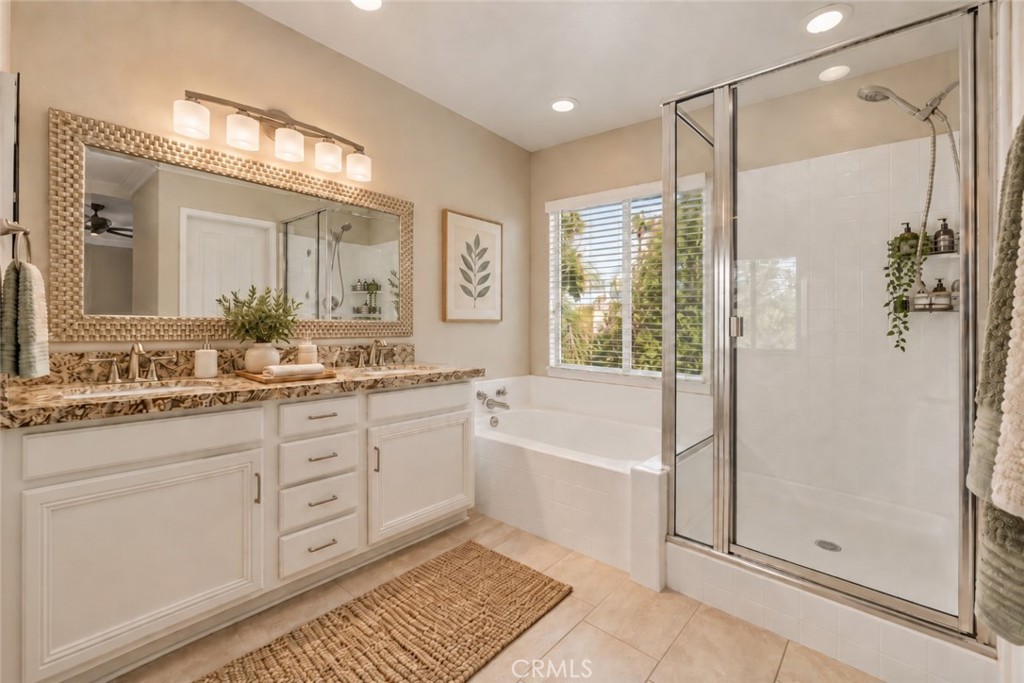Another View Of The Primary Bathroom Showcasing The Beautiful Vanity, Soaking Tub Beneath A Large Window, Separate Glass-Enclosed Shower, And Abundant Natural Light. Digitally Staged