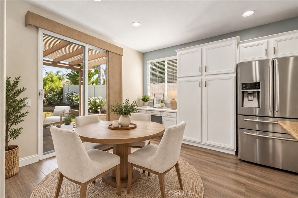 Charming Dining Area Featuring Wood-Look Flooring, Abundant Natural Light, Sliding Glass Door Access To The Backyard, And A Convenient Built-In Desk Area. Digitally Staged