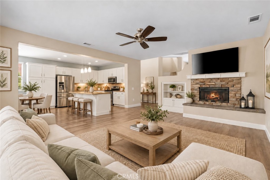 Beautiful Open-Concept Family Room Featuring A Stone-Surround Fireplace, Built-In Shelving, And A Seamless Connection To The Spacious Kitchen And Dining Area. Digitally Staged