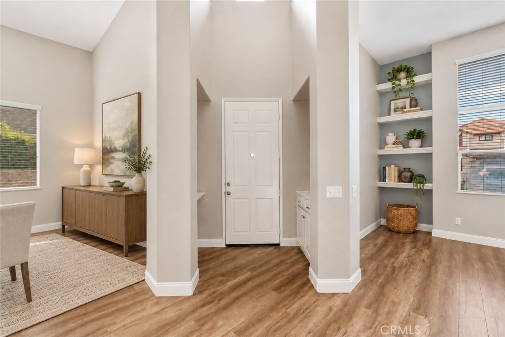 Bright And Inviting Entryway Featuring Soaring Ceilings, Attractive Wood-Look Flooring, And An Open View Of The Versatile Front Living Spaces. Digitally Staged