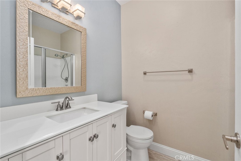 Well-Appointed Bathroom Featuring A White Vanity, Framed Mirror, Tub And Shower Combination, And Attractive Accent Wall.