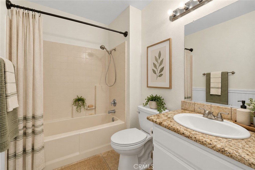 Additional full bathroom featuring a tub and shower combination, granite-topped vanity, and convenient storage. Digitally Staged