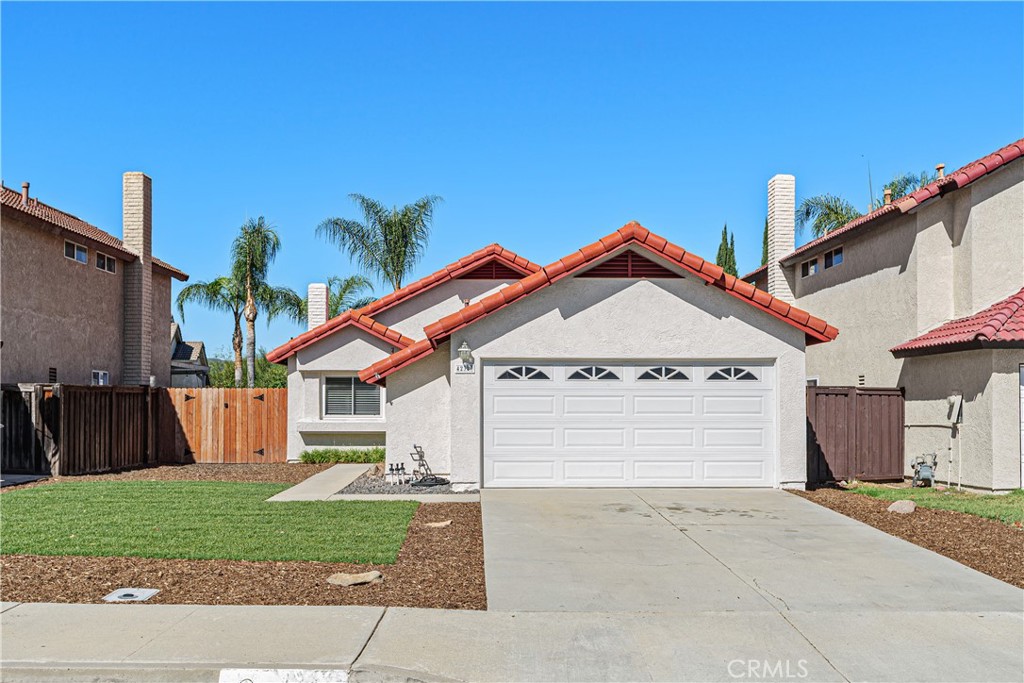 Welcome home! This inviting single-story residence features a two-car garage, tile roof, and low-maintenance front landscaping.
