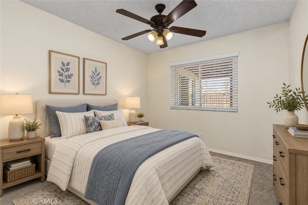 Secondary bedroom offering soft carpeting, a ceiling fan, and a window bringing natural light into the space. Digitally Staged