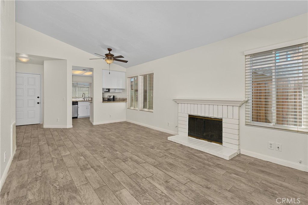 Another inviting view of the living room showcases the fireplace, natural light, and easy connection to the dining area and kitchen.