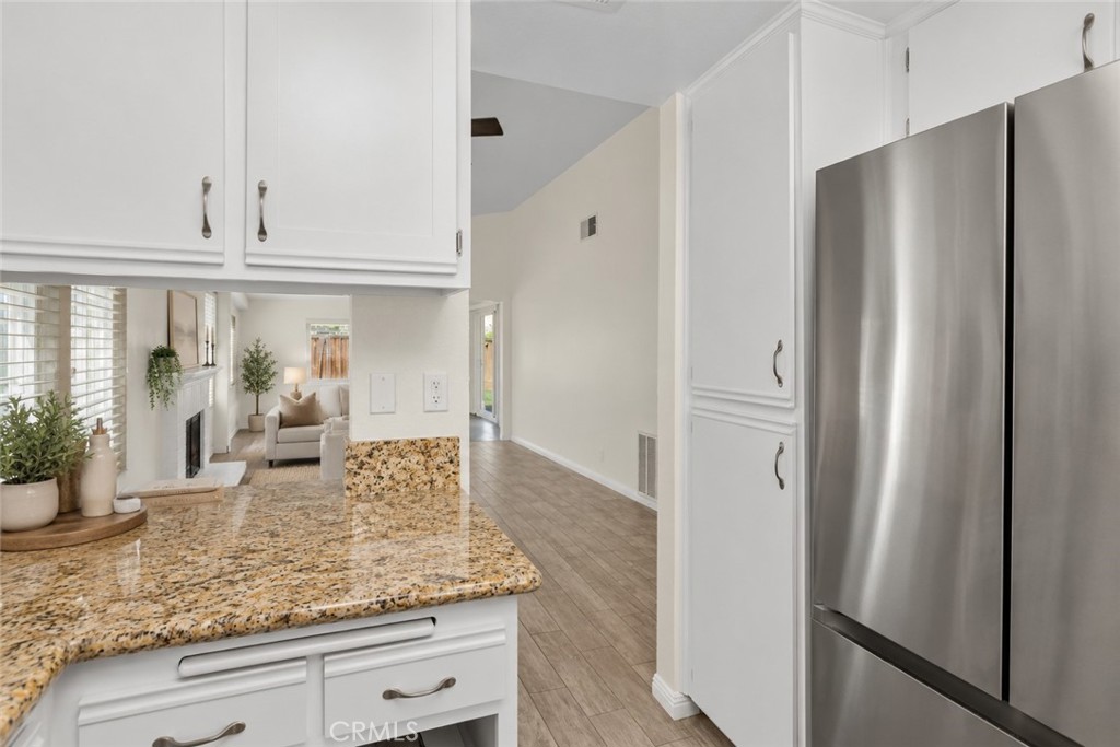 A view from the kitchen toward the living area showcases the home's open layout and convenient connection between the main gathering spaces. Digitally Staged
