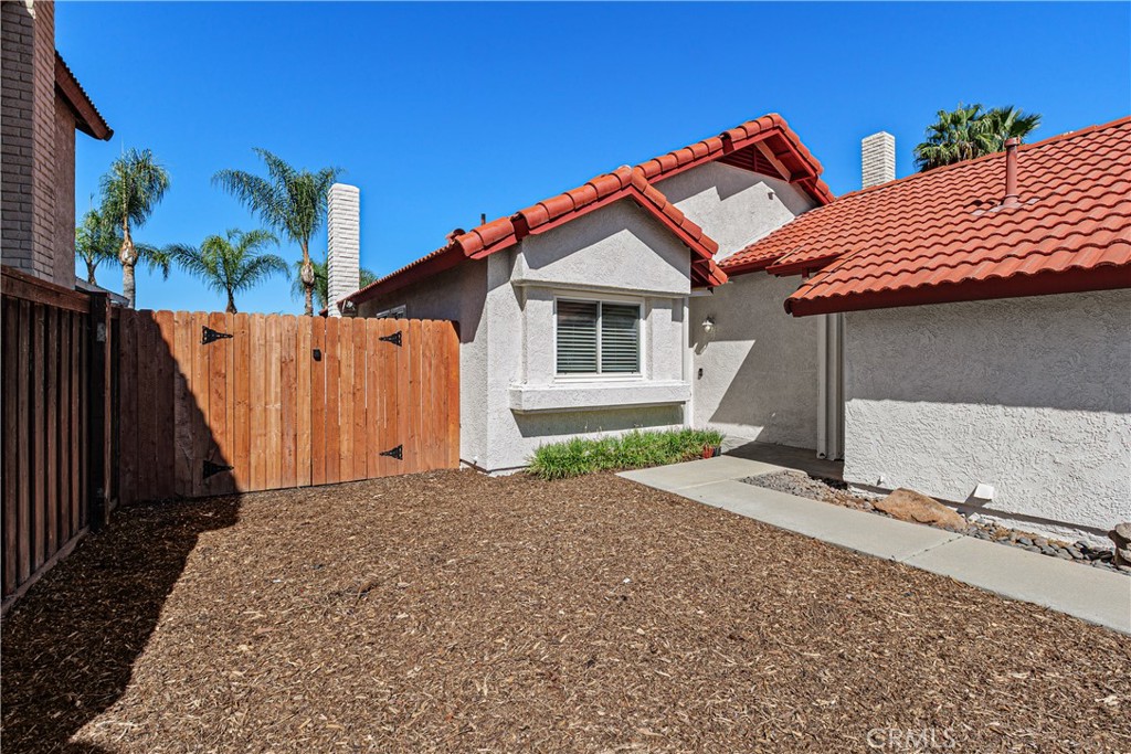Gated side yard offering low-maintenance landscaping and additional outdoor space. Gated side yard offering low-maintenance landscaping and additional outdoor space.