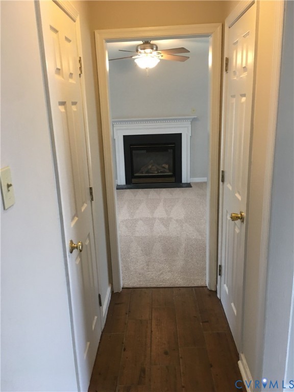 Corridor featuring dark wood-type flooring and baseboards