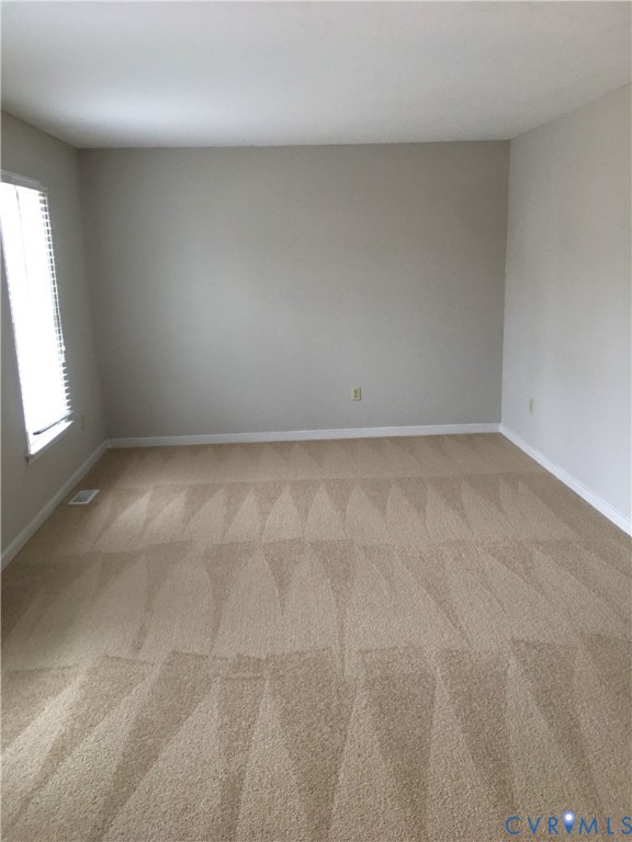 Empty room featuring light carpet