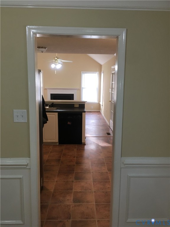Kitchen with dishwasher, dark tile patterned floors, vaulted ceiling, and ceiling fan
