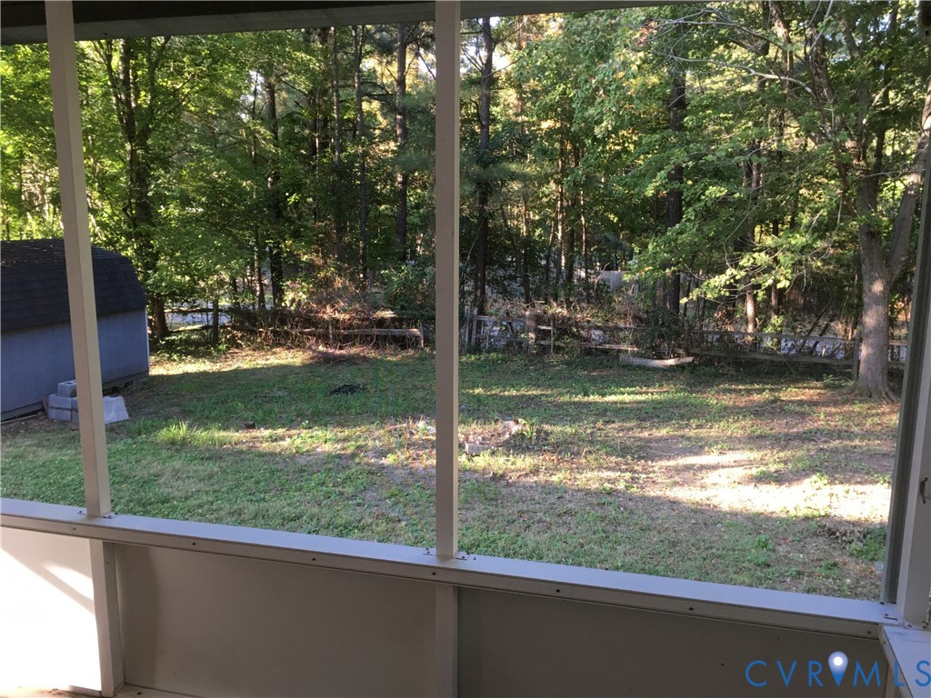 View of grassy yard featuring a storage shed