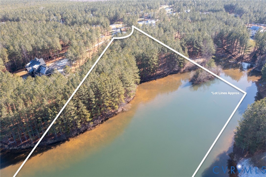 Aerial view of property and surrounding area with a heavily wooded area and property parcel outlined