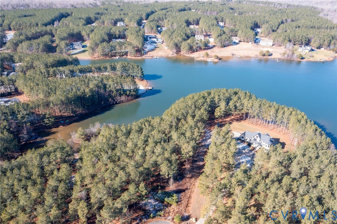 Aerial overview of property's location featuring a large body of water and a forest