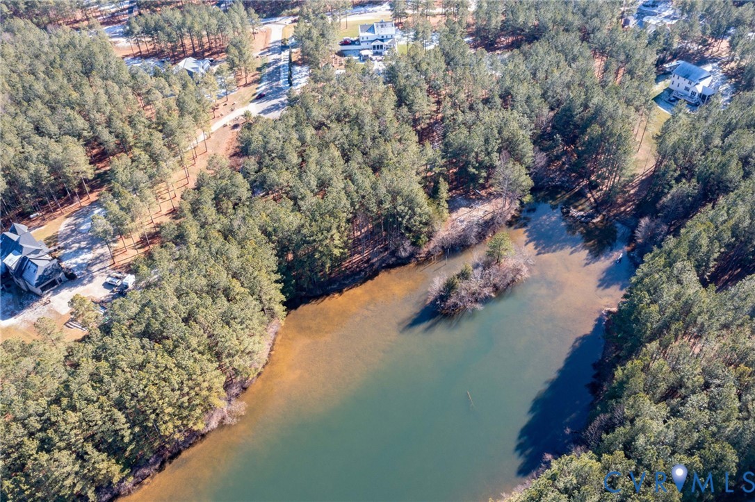 Aerial overview of property's location with a large body of water and a forest