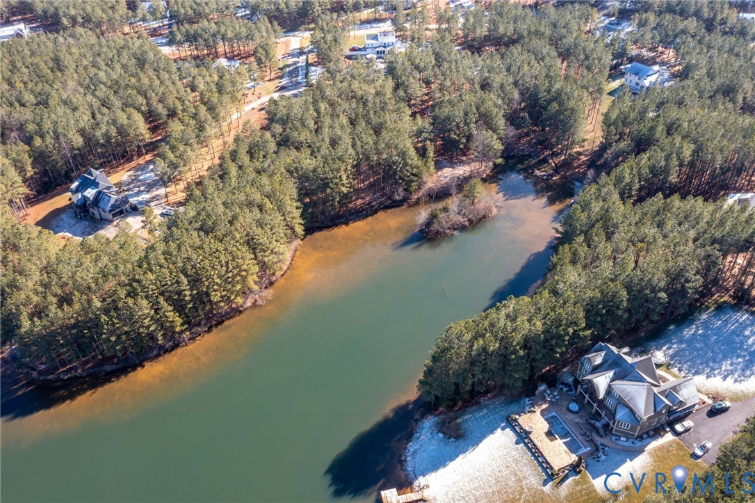 View of property location featuring a large body of water and a heavily wooded area