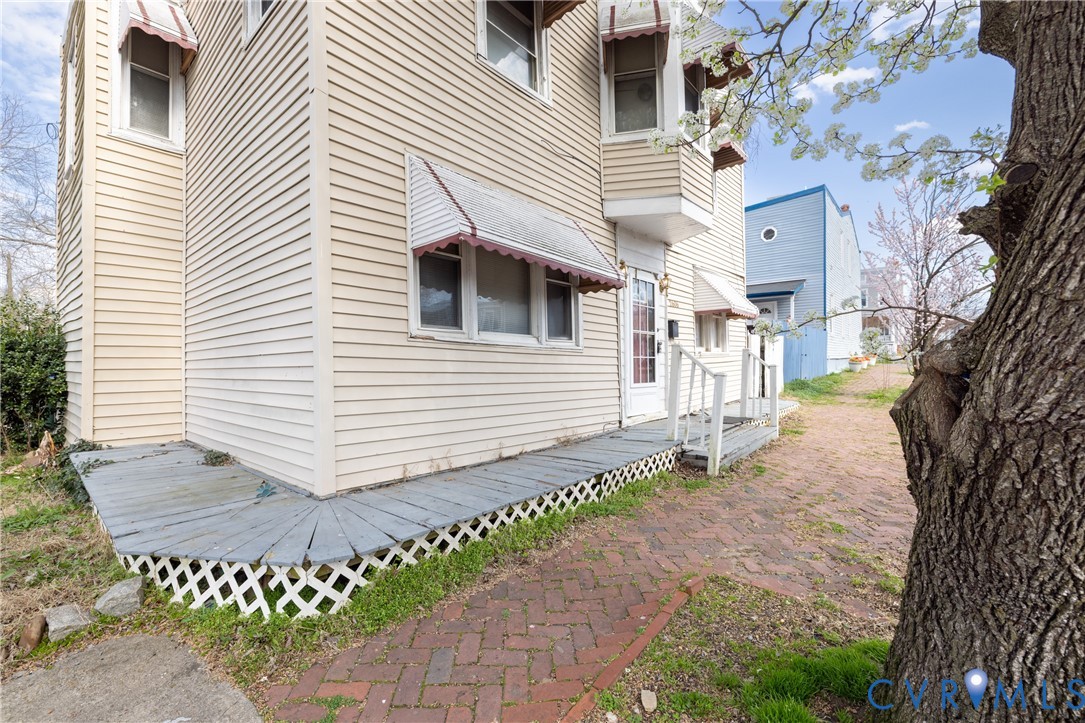 View of side of home featuring a wooden deck View of side of home featuring a wooden deck
