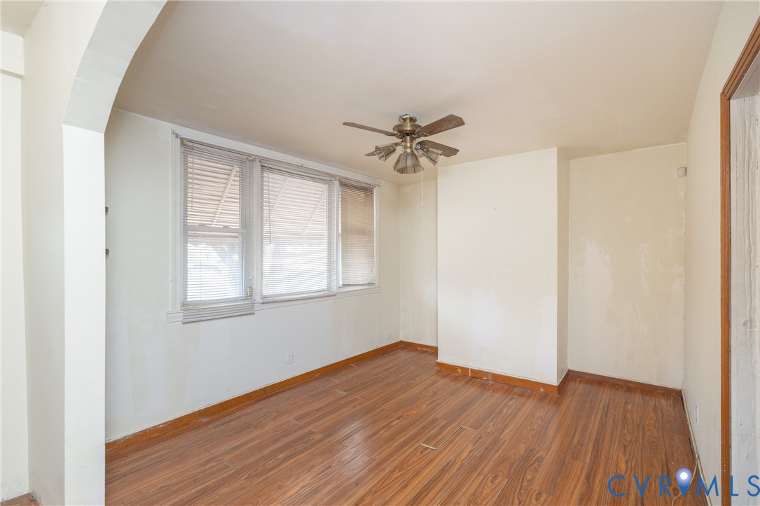 Unfurnished room with wood finished floors and a ceiling fan Unfurnished room with wood finished floors and a ceiling fan