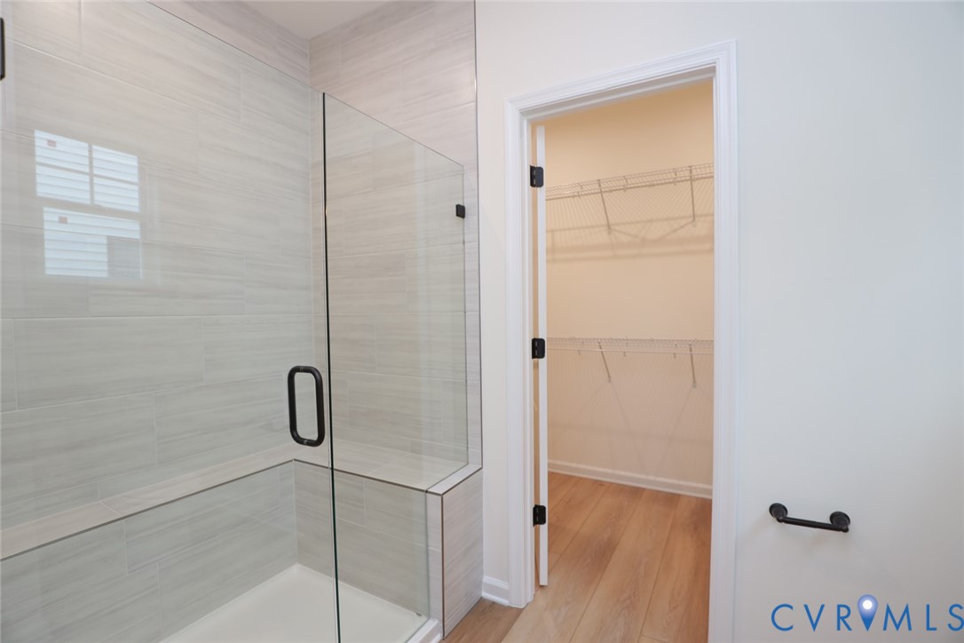 The photo represents the plan, not the actual home. Design selections may vary.  The first-floor primary suite offers a spacious walk-in closet and an ensuite bath with a double vanity, soaking tub, and linen closet.