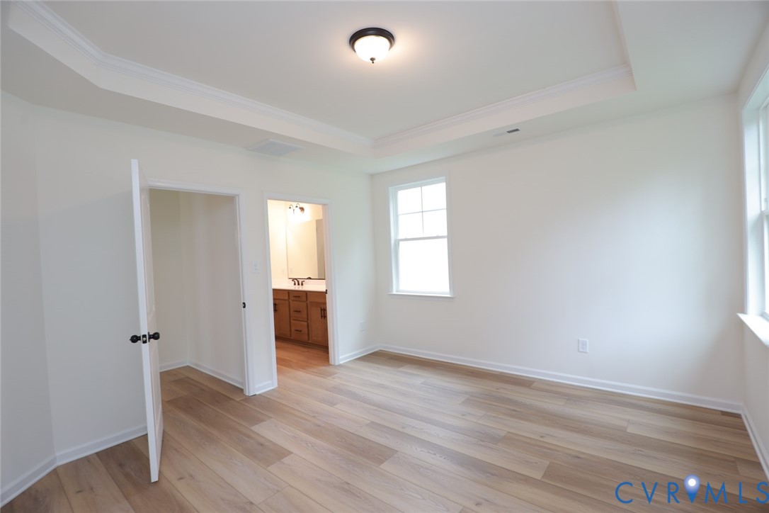 The photo represents the plan, not the actual home. Design selections may vary.  The first-floor primary suite offers a spacious walk-in closet and an ensuite bath with a double vanity, soaking tub, and linen closet.