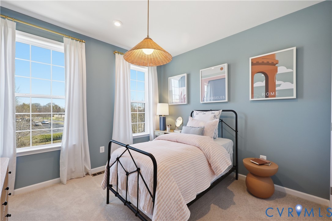 Room with light blue walls, two large double-hung windows, recessed lighting, and a woven pendant light fixture