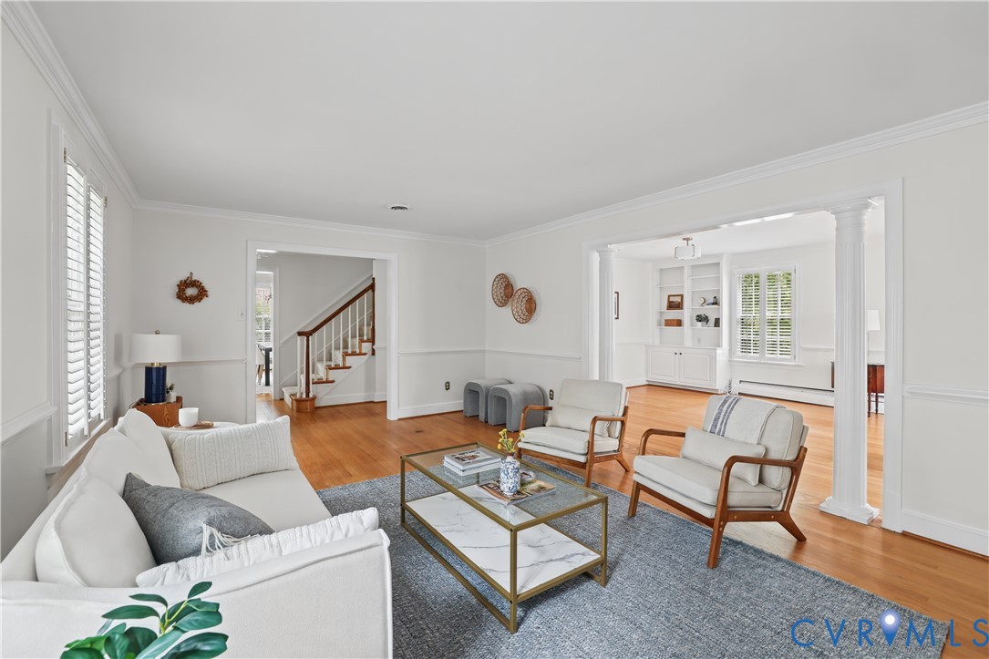 Hardwood flooring, crown molding, chair rail millwork, structural columns, and built-in shelving
