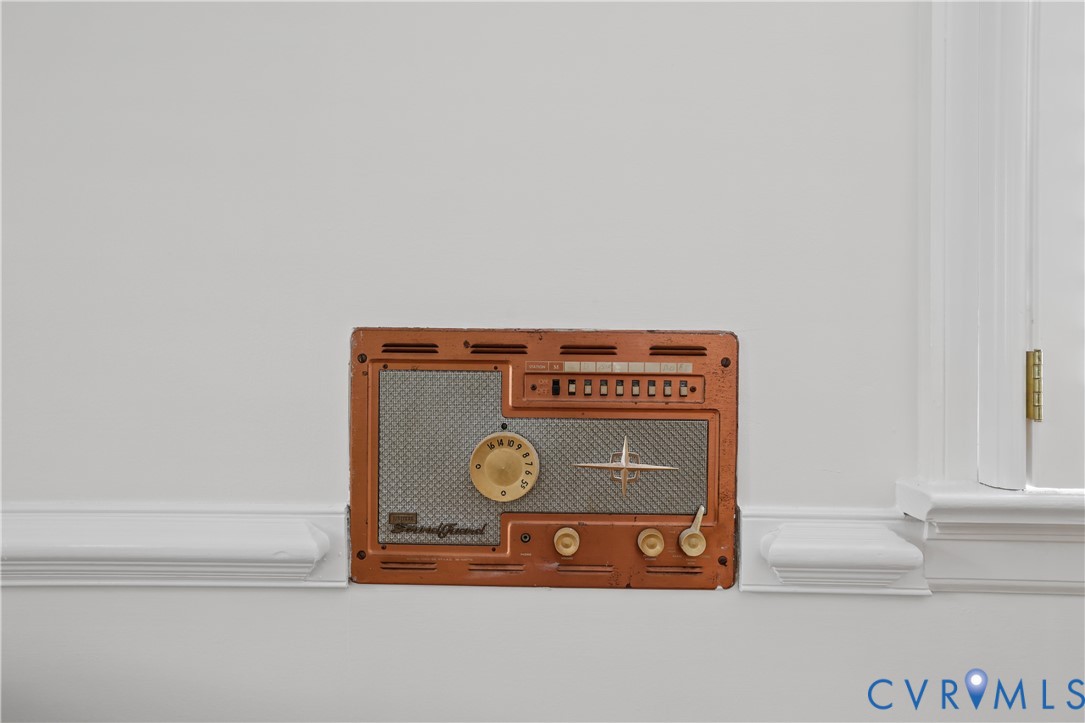Built-in copper-finish intercom system with metallic speaker grille, rotary dial, and tactile control switches