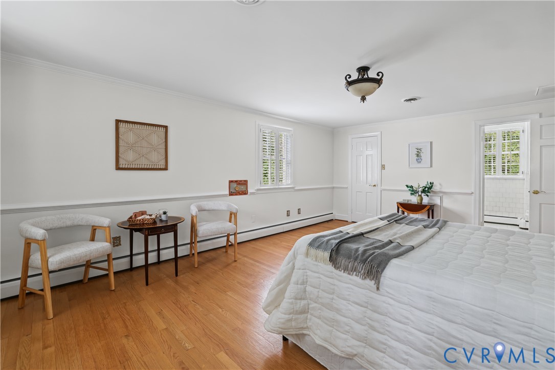 Spacious interior featuring wood-finish flooring, chair rail molding, multi-pane window with interior shutters, and a classic semi-flush mount light fixture